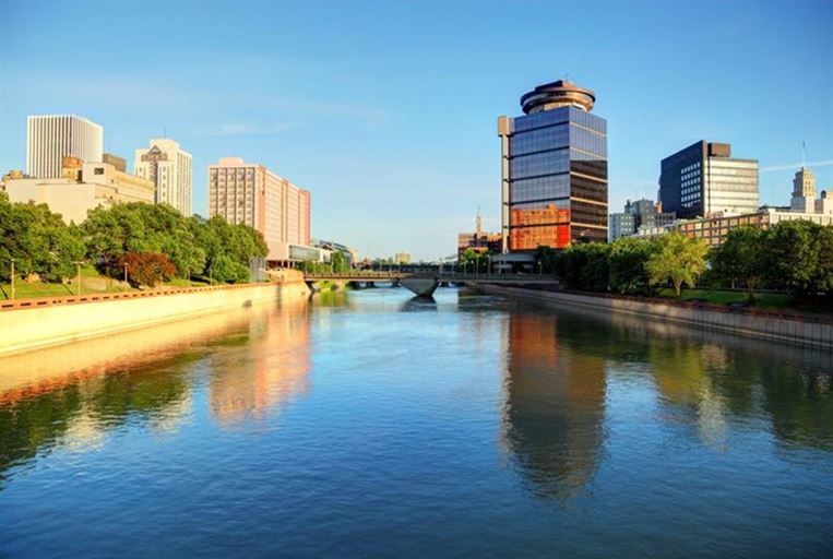 A river with a bridge and buildings in the background

AI-generated content may be incorrect.